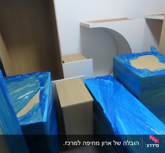 רהיטים עטופים בניילון כחול מוכנים להובלה